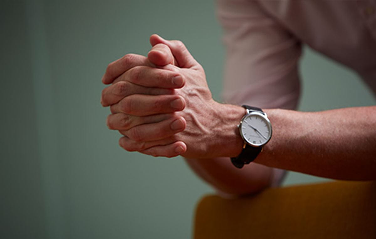 A person leaning against a chair. 
